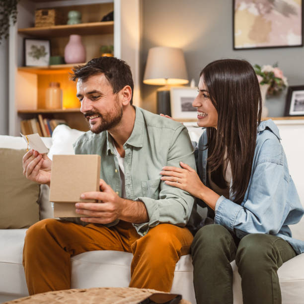 istock Boyfriend open his birthday present from his girlfriend at home 2156686967