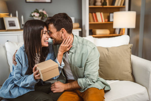 istock Girlfriend open her birthday present from her boyfriend at home 2156686968