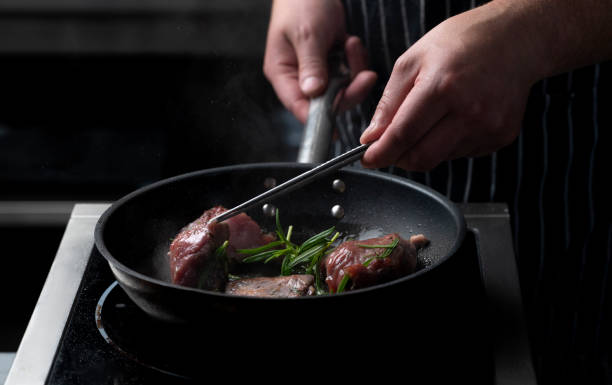 istock Chef frying meat steak 2156687072
