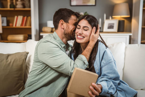 istock Girlfriend open her birthday present from her boyfriend at home 2156687132