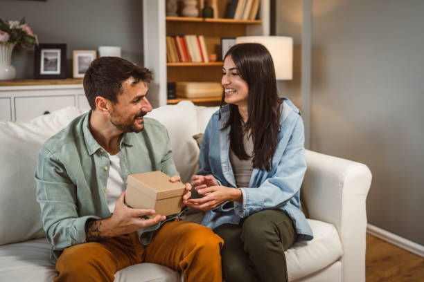 istock Boyfriend open his birthday present from his girlfriend at home 2156687241