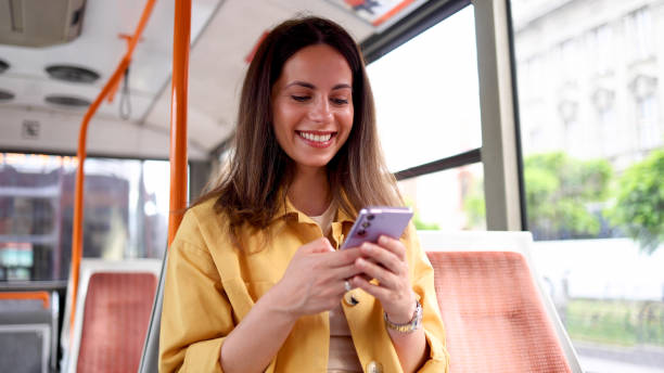 istock Young woman using smartphone in the city bus 2156687257