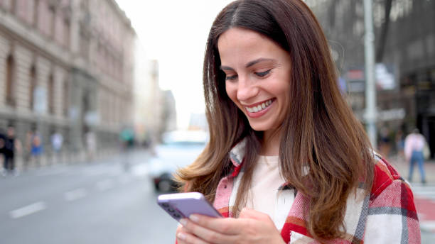 istock Happy young woman using smartphone on the move 2156687358