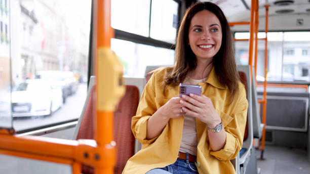 istock Happy woman surfing the net while riding in a bus 2156687421