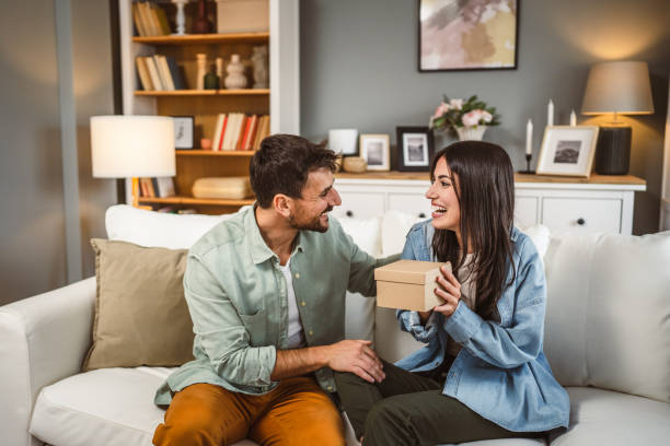 istock Girlfriend open her birthday present from her boyfriend at home 2156687433