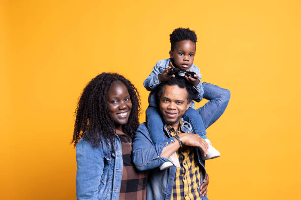 istock African american father carrying his son on his shoulders in studio, 2156689139