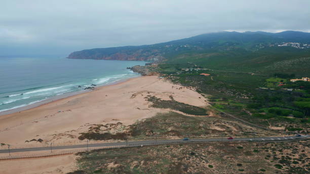 istock Sandy beach edged rugged coastline and ocean waves. Aerial view serene seaside 2156693373