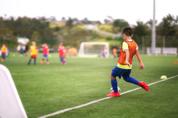 istock Boy kicking soccer ball while playing team sport. 2156697923