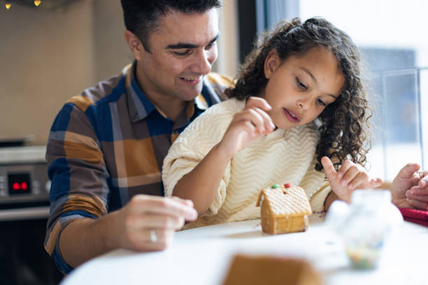 istock Father and Daughter Decorating a Gingerbread House 2156698076