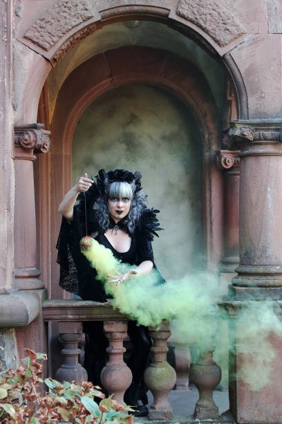 istock A woman dressed as an evil witch conjures with smoke 2156700572