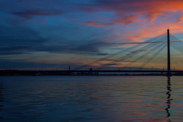 modern suspension bridge over the river at sunset