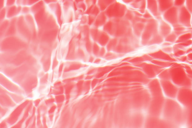istock Pink water with ripples on the surface. Defocus blurred transparent purple colored clear calm water surface texture with splashes and bubbles. Water waves with shining pattern texture background. 2156702666