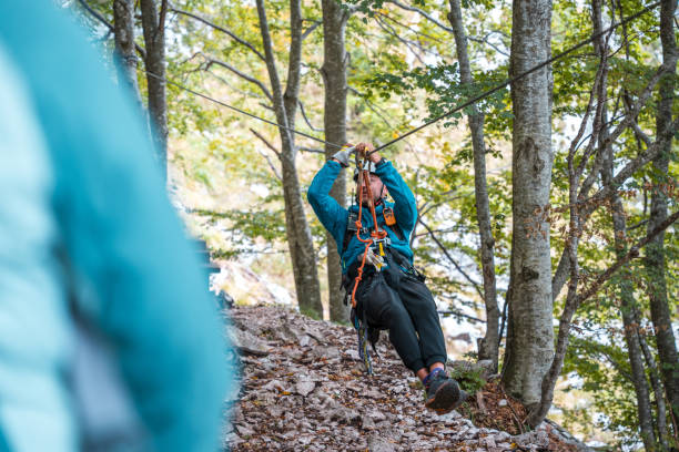 istock Caucasian Zip Line Instructor Demonstrating Safety Gear in Forest 2156703267