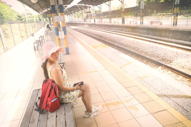 istock Young happy Asian woman at train station 2156704363