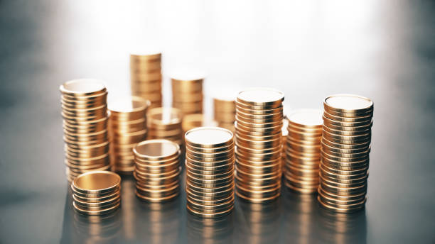 istock Stacks of coins on black reflective background 2156705363