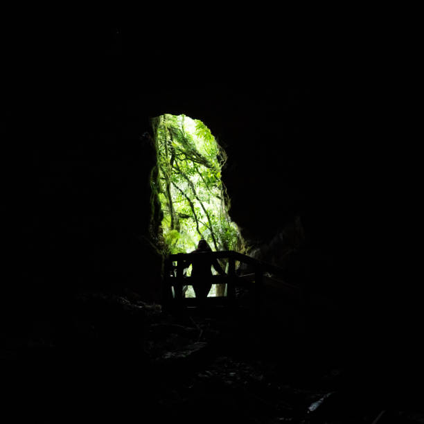 Person silhouetted in a cave opening