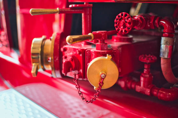 Close-up of red and gold fire truck equipment, including valves and hoses.