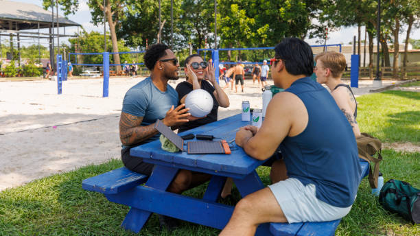 istock Sustainable energy solutions in everyday activities. Young multicultural adults enjoying break with solar panels at volleyball court 2156720158