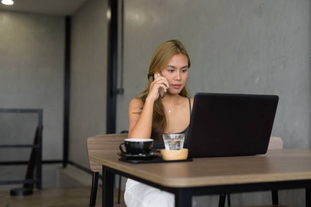 istock Beautiful woman sitting in cafe wearing professional clothing while using laptop computer 2156723273