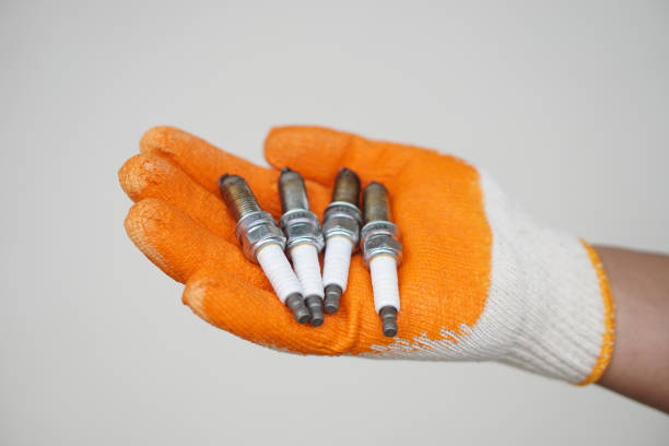 Close up mechanic hands hold old spark plug, spare part of car engine. Concept, machine maintenance, fix, repair, check or diagnose automobile problems by engine specialist.