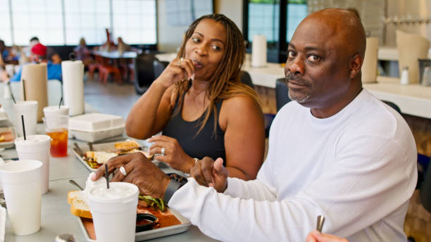 Husband Looking at Camera While Wife Stares at Him in BBQ Restaurant