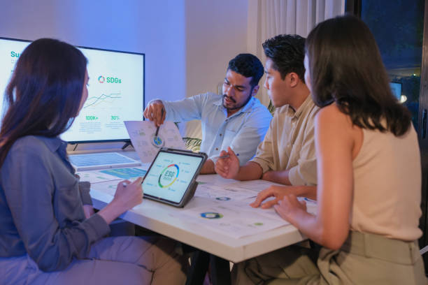 istock diversity team discusstion about esg and eco friendly system planning in sustainable green office at night 2156727644