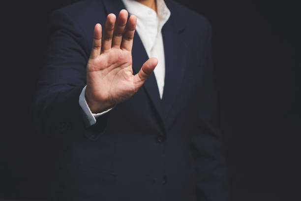 istock Businessman shows a stop gesture while standing on a black background. 2156728776