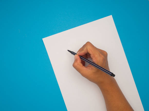 istock Right hand holding a pen for writing on empty white paper over a blue background. 2156728862