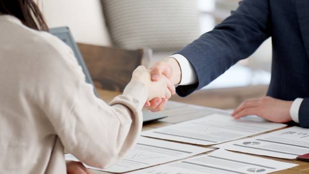 Businessmen shaking hands during a sales call stock photo