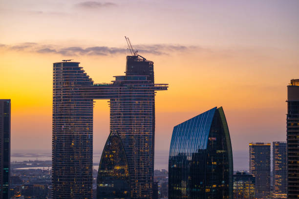 Discover the stunning high-rise skyscrapers of Dubai’s financial district at sunset, showcasing modern architecture and the vibrant economic hub of the city, a testament to its rapid growth and innovation.