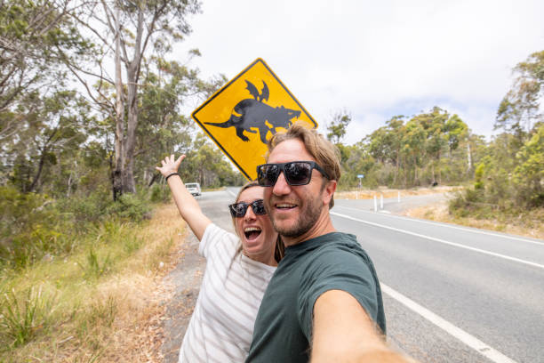 istock Smiling Couple Posing with Humorous Dragon Crossing Sign 2156741490