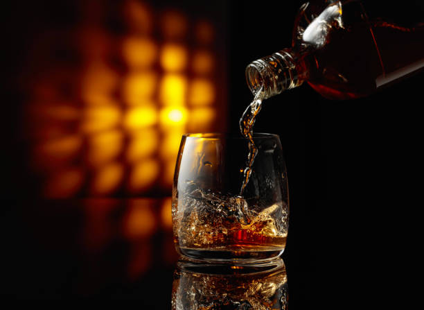 istock Pouring whiskey from a bottle into a glass. 2156742056