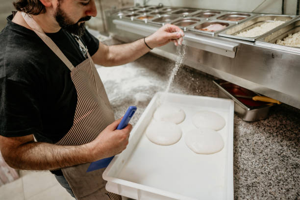istock an adult handsome pizza baker making pizza 2156742279