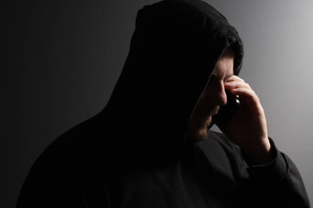 istock Identity thief, a man talking on the phone, committing a crime, engaging in stealing, causing security risk. 2156742661