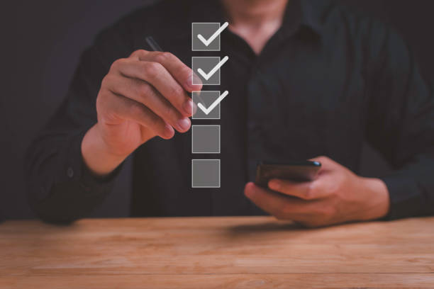 istock Business checklist and online survey for performance evaluation. Businessman using laptop to fill out digital form and take assessment questionnaire. Conducting online exam and checklist review. 2156745786