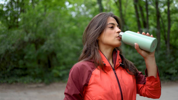 istock Woman drinking water while hiking 2156746179