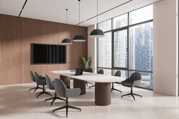 istock Beige office interior with meeting table and chairs, tv screen and window 2156748705