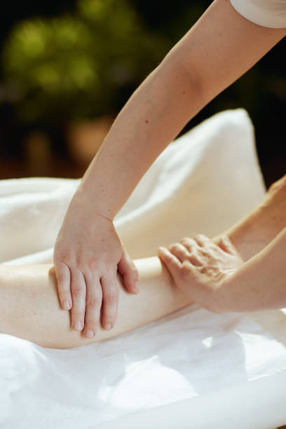 istock Massage therapist in massage cabinet massaging clients leg 2156749833