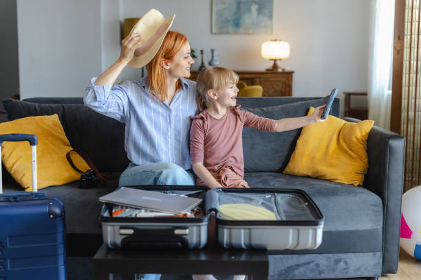 istock Mother and daughter taking selfie while packing for a summer holiday 2156758958