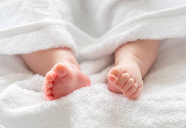 istock Baby's little legs nestled under a soft veil. Concept of infant tenderness post-bath routine 2156766312