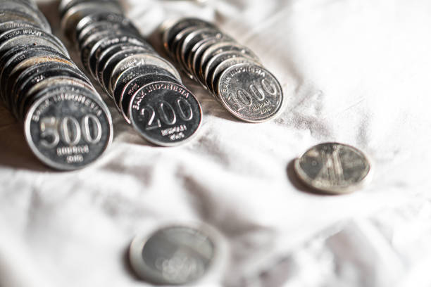Close-up of South Korean coins of different denominations, including 500, 200, and 100 won, arranged on a white cloth.