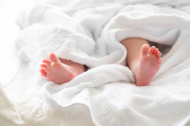 istock Tiny newborn feet gently emerge from a towel. Concept of post-bath serenity 2156771114