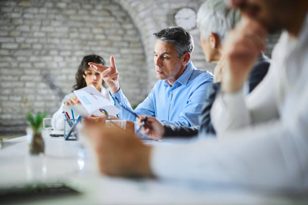 istock Male entrepreneur going through reports with his colleagues on a meeting. 2156773122