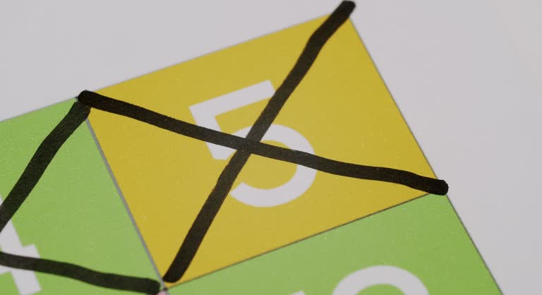 Closeup of Hand Drawing Line Across Bingo or Lottery Number Five