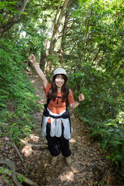 Female hiker walking up mountain - punching the air