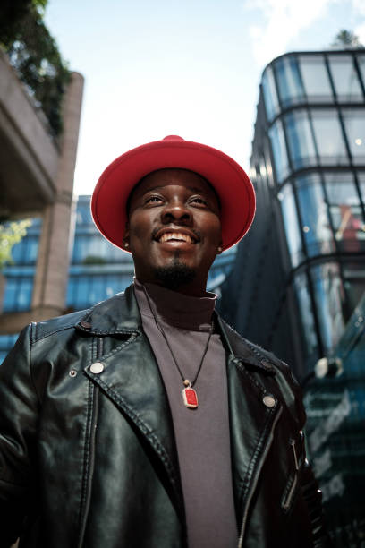 istock Smiling male model looking away and posing between high buildings. 2156782031