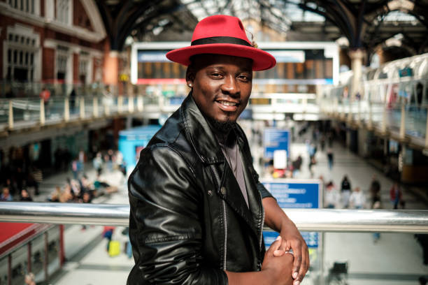 istock Happy black man posing in a train station leaning on a banister. 2156782048