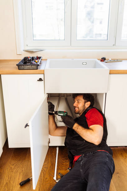 istock Young man as a plumber working on pipes under sink in the kitchen 2156782075