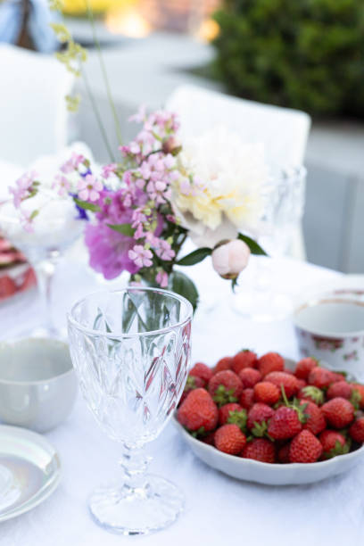 istock decorated table, glass, flowers and plate with strawberries 2156783100