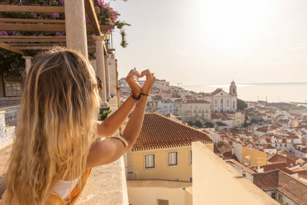 istock Woman Making Heart Shape with Hands Overlooking Lisbon's Alfama District 2156783105